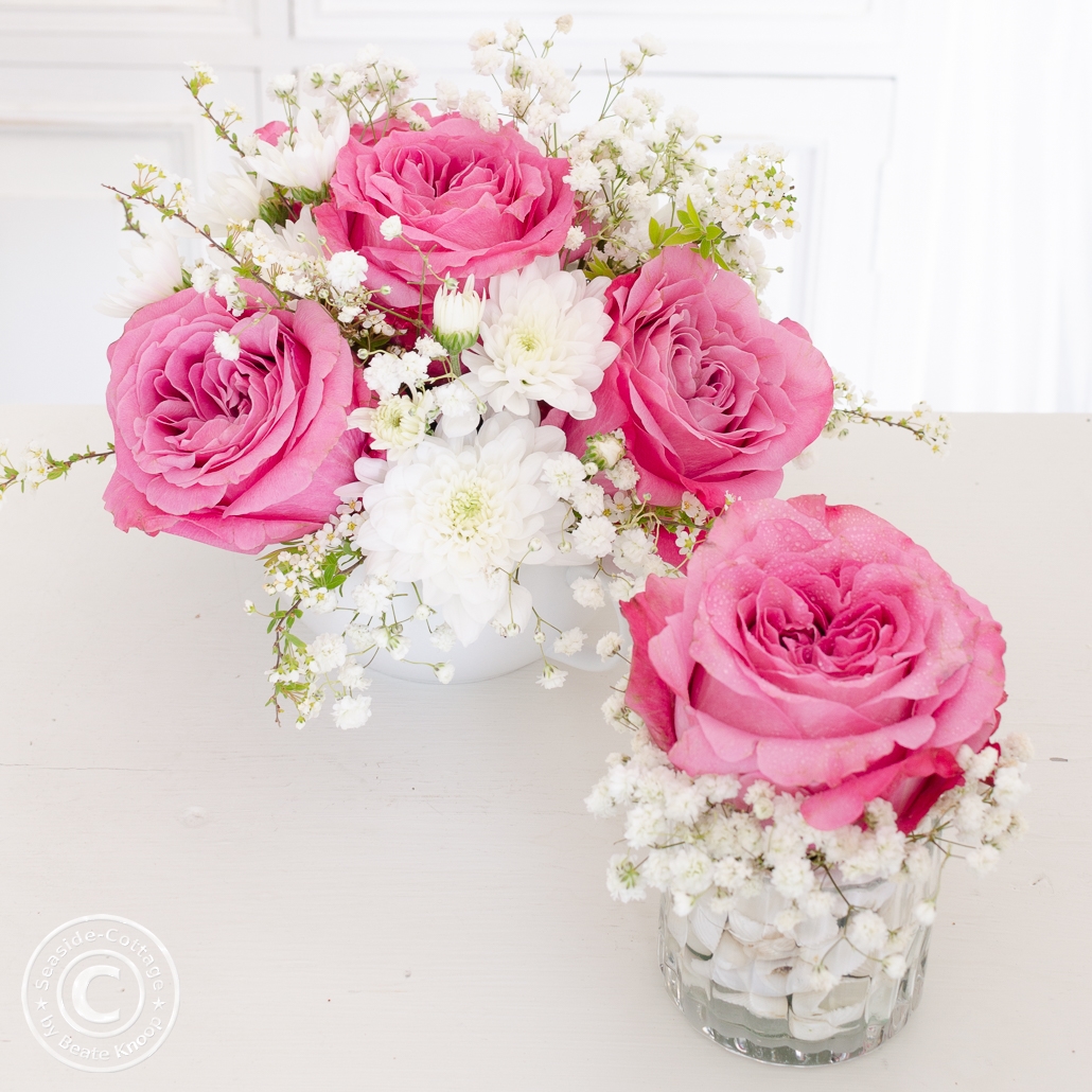 Blumendeko mit Rosen und Schleierkraut in rosa und weiß