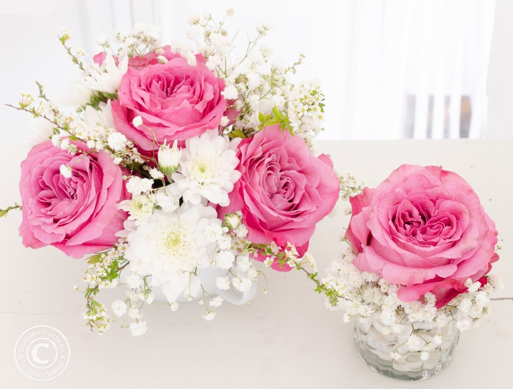 Blumendeko mit Rosen und Schleierkraut in rosa und weiß