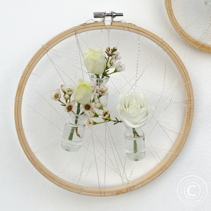 stickrahmen_mit_blumen_02 Stickrahmen als Wanddeko mit kleinen Blumenvasen mit Waxflower und Eustoma