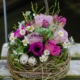 Nest aus Hopfenrebe geüllt mit pinkfarbenen Anemonen und Tulpen, fliederfrabenen Rosen, Edelkamille, Heildebeergrün und Wachteleiern