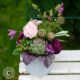 Sommerliche Tischdeko mit Artischocke, rosa Rosen, Hortensie, Dahlien, Waldreben, grünen Brombeeren und Wiesenknöpfchen