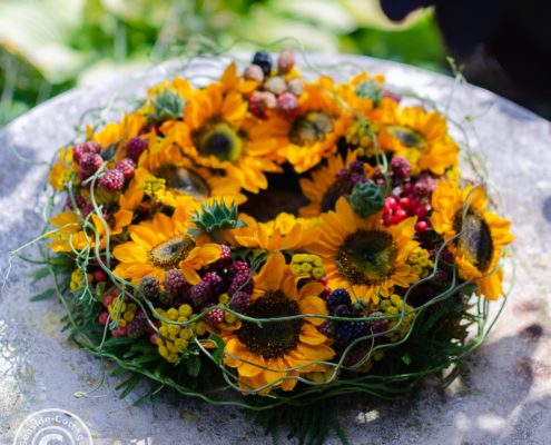 Kranz mit Sonnenblumen auf rundem Gartentisch