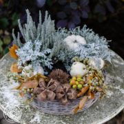 herbstliche dekorierter Pflanzring auf einem verwittertem Gartentisch