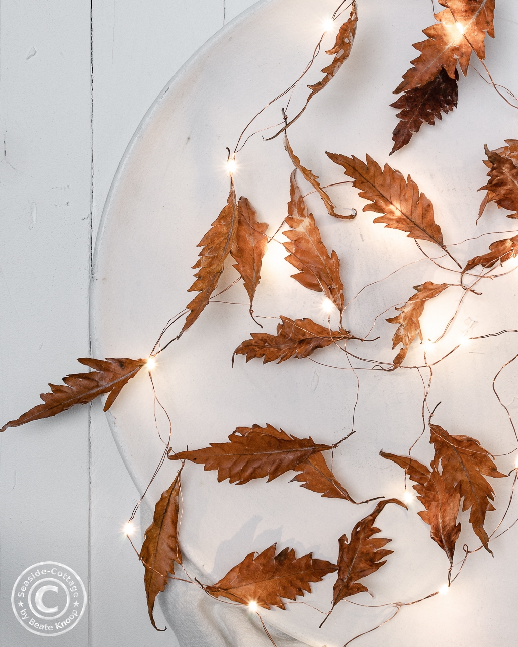 Gewachste Herbstblätter mit Lichterkette